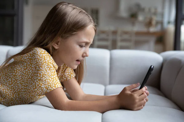 Small Caucasian girl use smartphone playing game — Stock Photo, Image