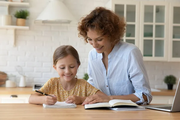 Feliz niña y mamá estudian juntas en casa — Foto de Stock