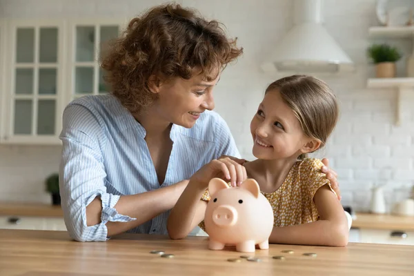 Happy young mom and daughter saving for future — Stock Photo, Image