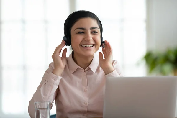 Bilgisayarda kulaklık takmış gülümseyen Hintli kadın çalışan — Stok fotoğraf
