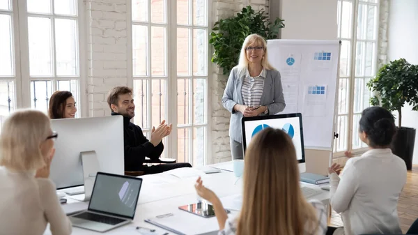 Diversos empleados aplauden saludo entrenador femenino en la reunión — Foto de Stock