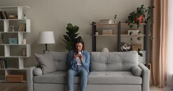 Vrouw die sms 'jes leest vieren geweldig nieuws springt voelt zich opgewonden — Stockvideo