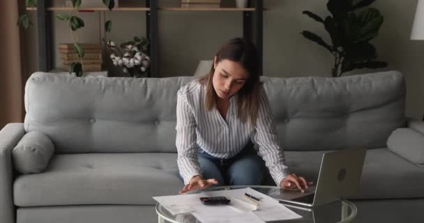 Serious woman calculates expenses, pay utility bills through online bank — Stock Video