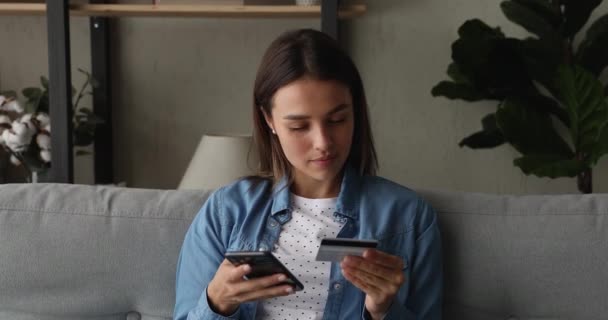 Mulher segurando cartão de crédito e smartphone faz compra na internet — Vídeo de Stock