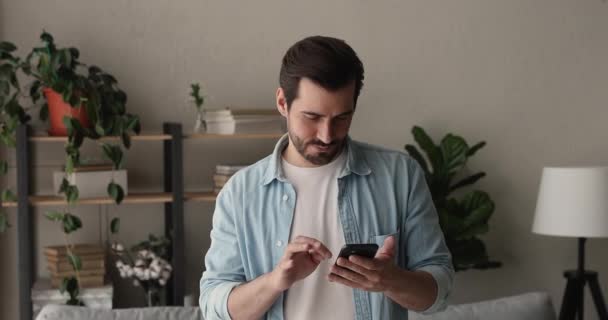 Young business man with smart phone standing indoor — Stock Video