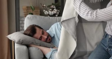 Sevgi dolu eş, uyuyan sevgili erkeği sıcak ekoseyle örter.