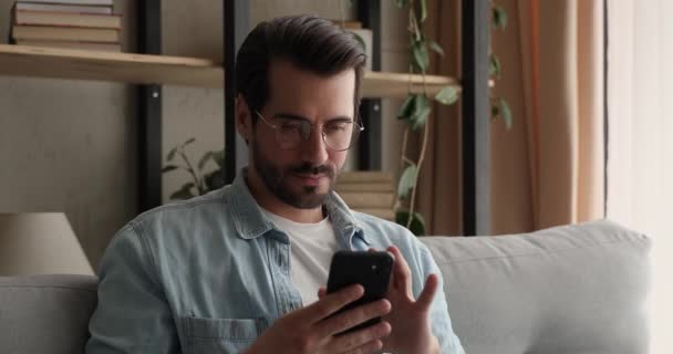 Jovem segurando smartphone ler sms aviso com grande notícia — Vídeo de Stock