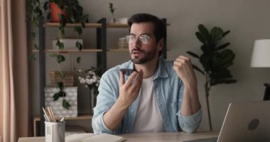 İş adamı masada oturur, akıllı telefon kullanır, hoparlör kullanır.