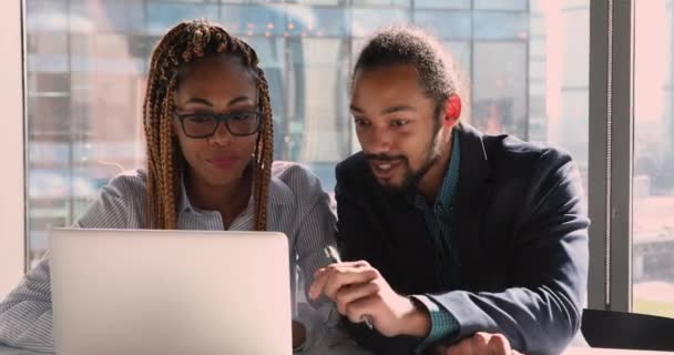 查看手提电脑屏幕的非洲族裔同事讨论协作项目 — 图库视频影像