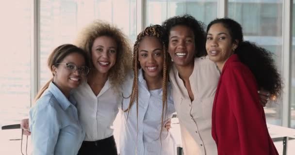 Cinco mujeres africanas exitosas miembros del personal abrazándose posando en el cargo — Vídeo de stock