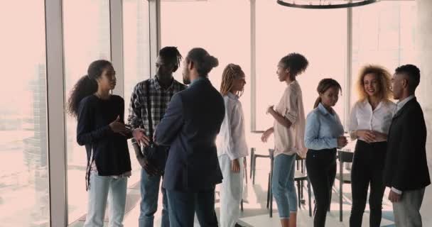 Африканские сотрудники разделились на группы, беседующие во время перерыва в зале заседаний — стоковое видео