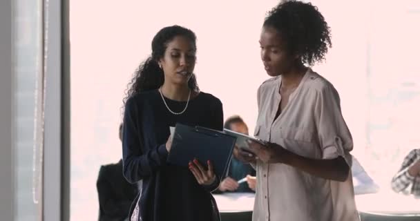 Mulheres de negócios africanas caminham ao longo da sala de escritório discutindo projeto colaborativo — Vídeo de Stock