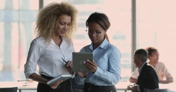 两名非洲女雇员讨论使用平板电脑的在线项目 — 图库视频影像