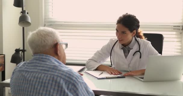 Feliz joven trabajadora médica médico consultando paciente de edad. — Vídeos de Stock