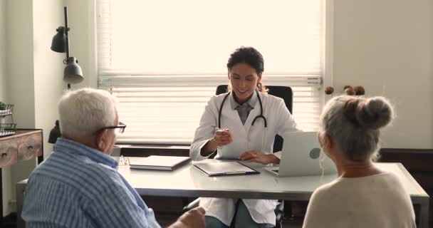 Sorrindo jovem médico consultando casal velho família. — Vídeo de Stock