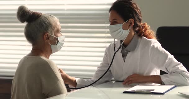 Attentif professionnel cardiologue femme vérifier coeur de vieux patient. — Video