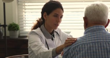 Merhametli bayan G.P. toplantıda yaşlı hastaya destek oluyor..