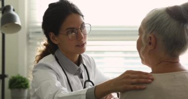 Toplantıda yaşlı kadını destekleyen kendinden emin genç bir doktor..