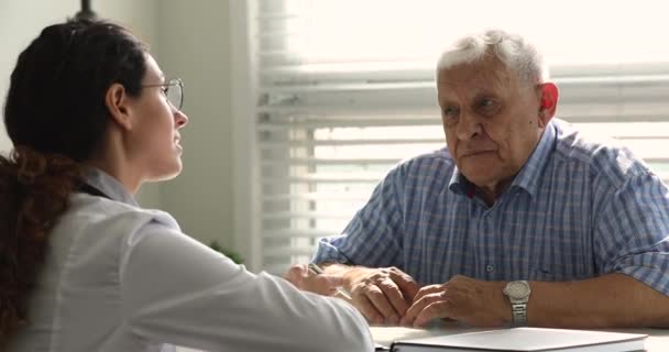 Jeune femme médecin écoute patient masculin plus âgé. — Video