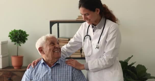 Junge Ärztin unterstützt alten Mann. — Stockvideo