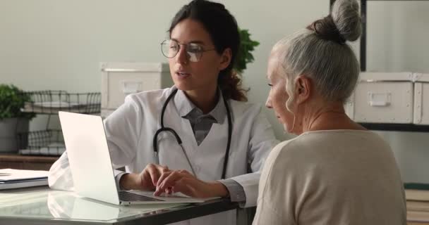 Médecin professionnel montrant les résultats des tests sur ordinateur à un vieux patient. — Video