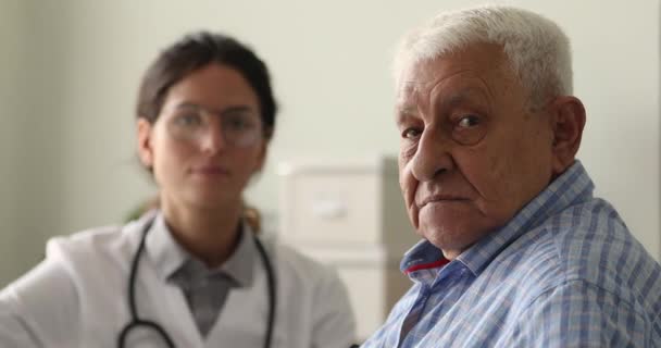 Närbild porträtt av glad gammal patient med skicklig läkare. — Stockvideo