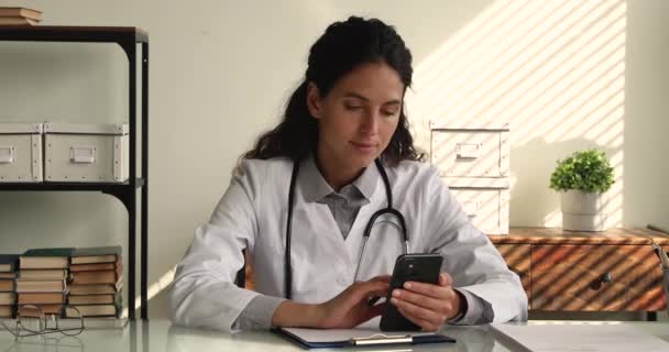 35s médico femenino usando smartphone en la clínica. — Vídeos de Stock