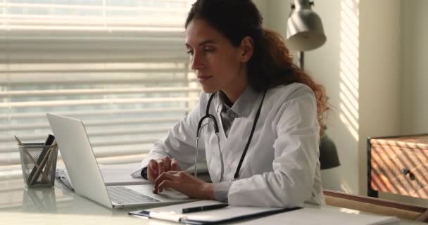 Zaměřená mladá praktická lékařka pracující na počítači. — Stock video