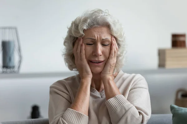 Upset exhausted mature 60s woman suffering from headache — Stock Photo, Image