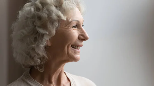 Vue de côté portrait de heureuse vieille femme des années 70 regardant loin — Photo