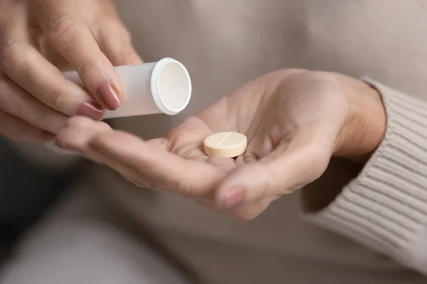 Mature woman holding plastic tube with medication — Stock Photo, Image