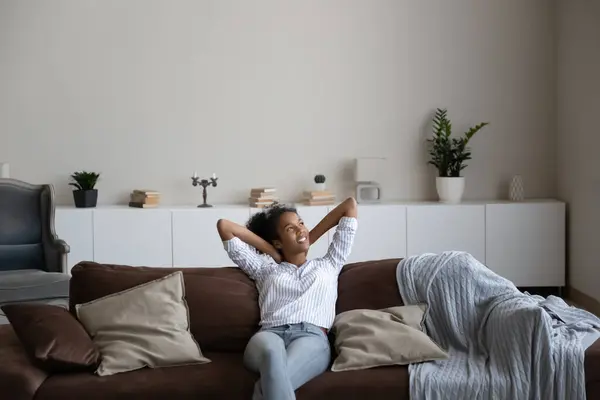 Happy biracial woman rest on sofa in cozy home — Stock Photo, Image