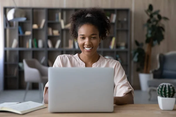 Smiling young biracial woman work online on laptop — Stock Photo, Image