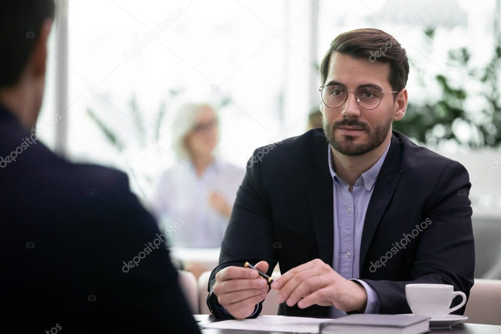 Confident young businessman talk with client at meeting
