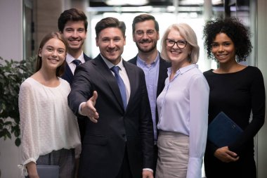 Erkek CEO, ofiste yeni bir çalışanla el ele görüşüyor.