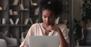 Bilgisayarda çalışan odaklanmış Afrikalı genç iş kadını.