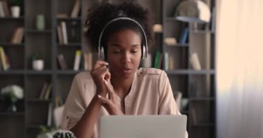Milenyum Afrikalı Amerikalı iş kadını kulaklıklı video görüşmesi yapıyor..