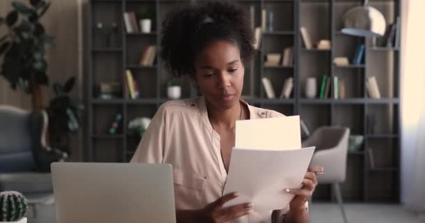 Jonge Afro-Amerikaanse zakenvrouw werkt met papieren documenten. — Stockvideo