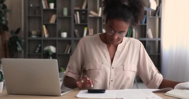 Soustředěný mladý šťastný africký americký žena výpočet výdajů on-line. — Stock video