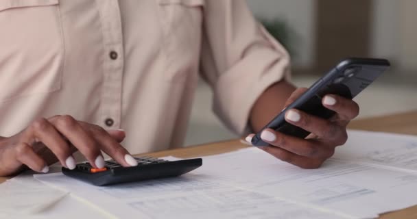 Närbild ung afrikansk kvinna hantera budget i mobilappen. — Stockvideo