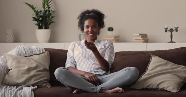 幸せな若いですアフリカ系アメリカ人女性見てスマートテレビホーム. — ストック動画