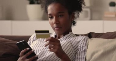 Genç Afrikalı kadın mobil uygulama ile alışveriş yapıyor..