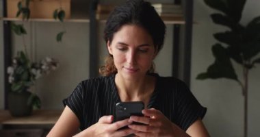 Gülümseyen çekici milenyum kadını akıllı telefondan mesaj atıyor..