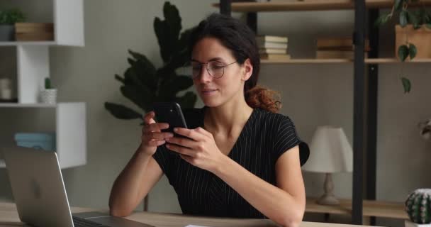 Sonriendo hermosa mujer de negocios milenaria utilizando aplicaciones de teléfonos inteligentes. — Vídeos de Stock