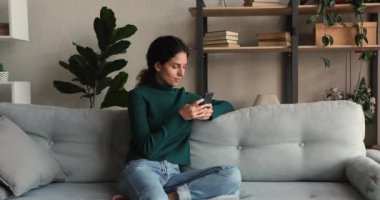 Mutlu milenyum çekici kadını evde akıllı telefon kullanıyor..