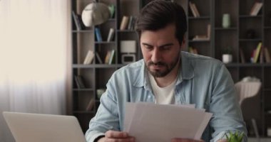 Mutlu 30 'lu yaşlardaki genç adam kâğıt okuyor..