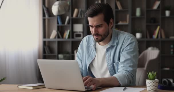Стрессовый молодой человек смотрит на экран компьютера. — стоковое видео