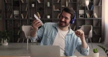 Mutlu genç iş adamı ofiste müzik dinliyor..