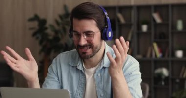 Kulaklıklı genç adam kameralı zoom toplantısı yapıyor..