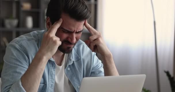 Hombre malsano joven estresado que sufre de dolor de cabeza severo. — Vídeos de Stock